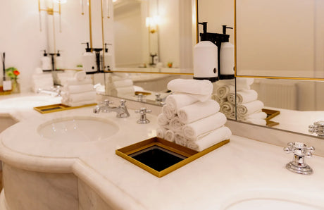 Modern bathroom vanity with a large mirror flanked by two wall sconces casting warm, even light