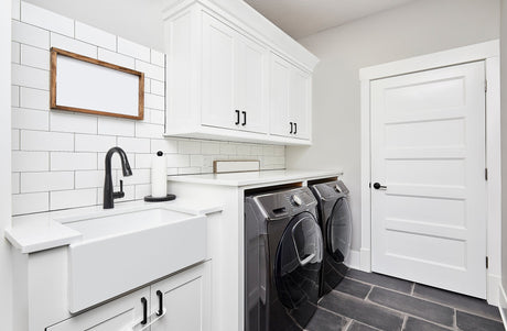 Bright laundry room with a deep stainless steel laundry sink and tall pull-down faucet