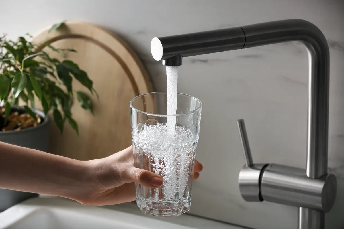 Kitchen faucet filling a glass with water