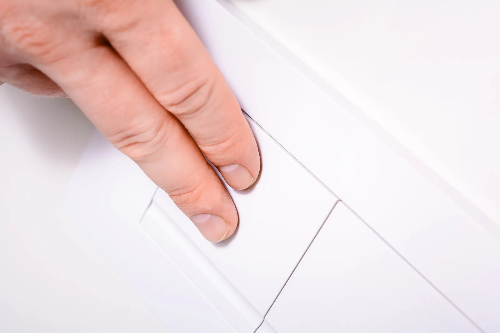 Hand pressing the button of a dual-flush toilet
