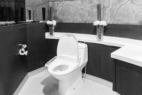White ceramic toilet with integrated electronic bidet seat in a modern bathroom