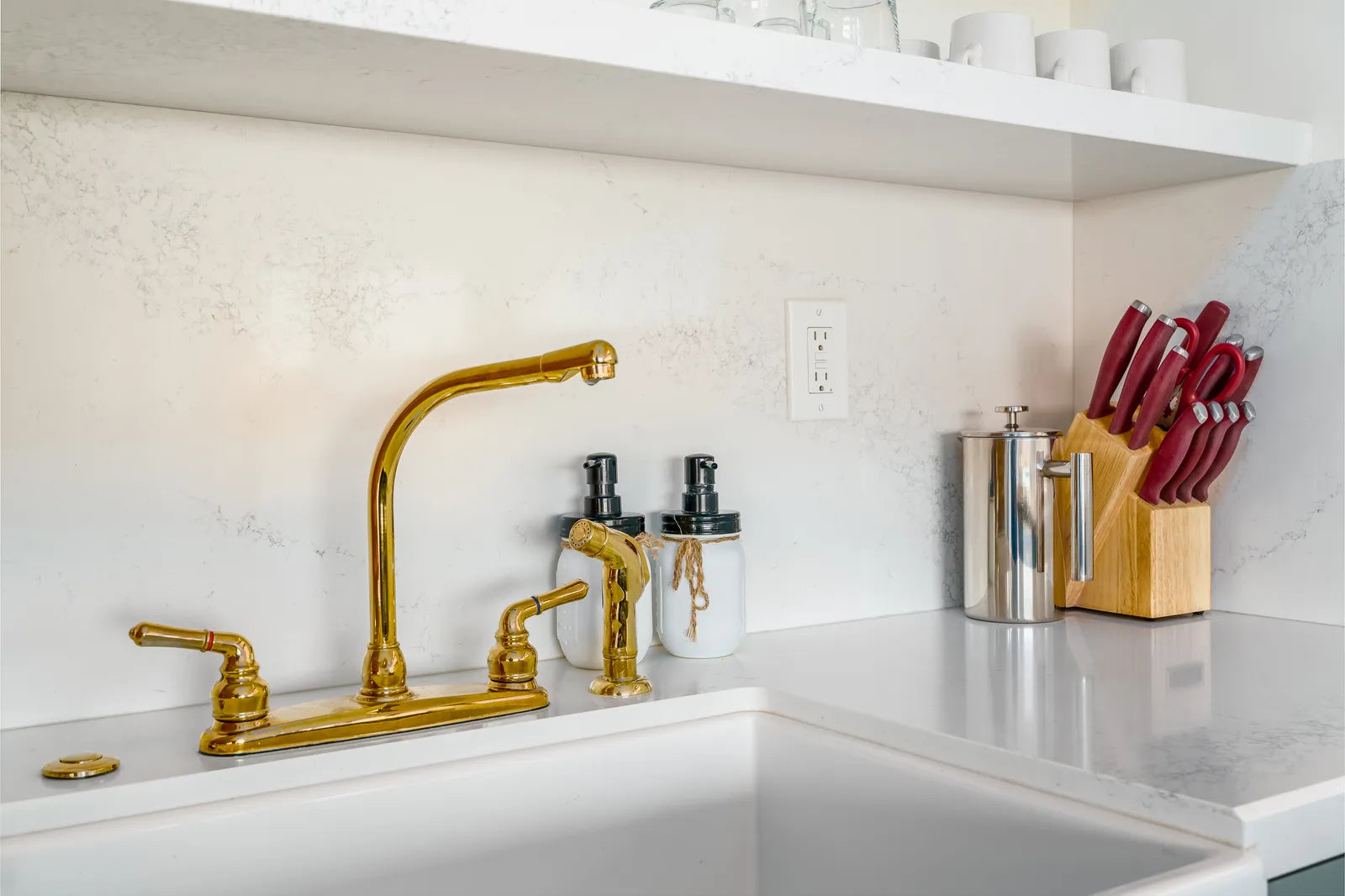Unlacquered brass faucet developing a warm patina above a kitchen sink