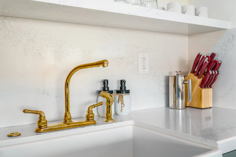 Unlacquered brass faucet developing a warm patina above a kitchen sink