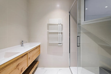 White acrylic shower base with a low threshold and glass door in a renovated bathroom