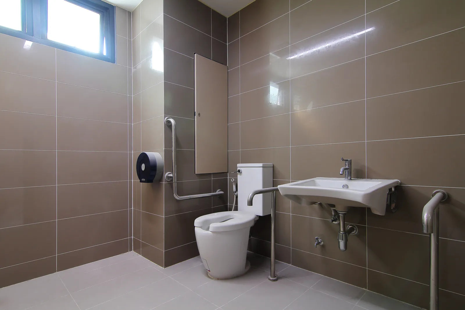 Newly built accessible bathroom with support rails beside the toilet