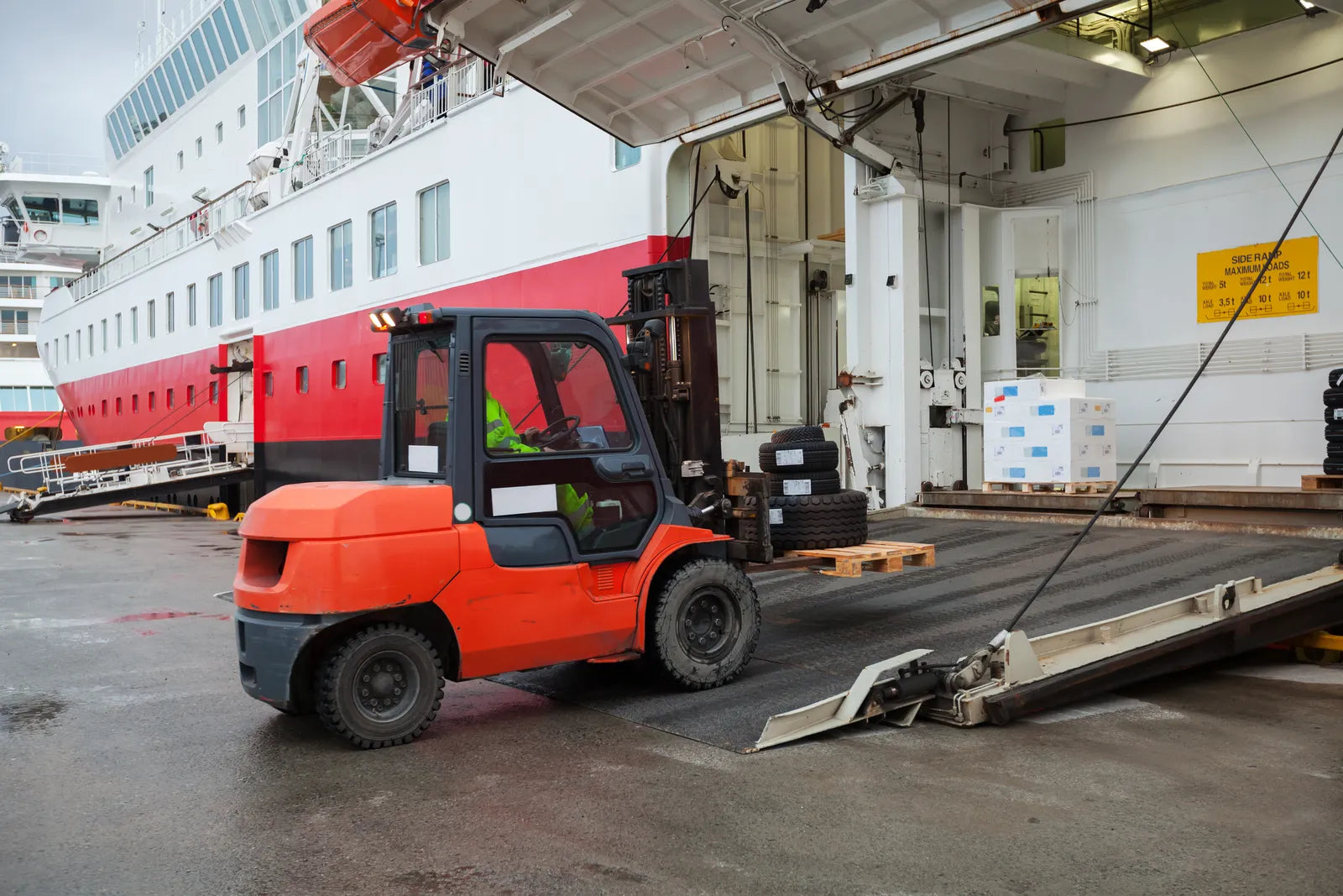 Delivery driver lowering a crated shipment on a freight truck liftgate for curbside home delivery