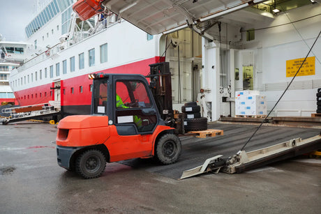 Delivery driver lowering a crated shipment on a freight truck liftgate for curbside home delivery