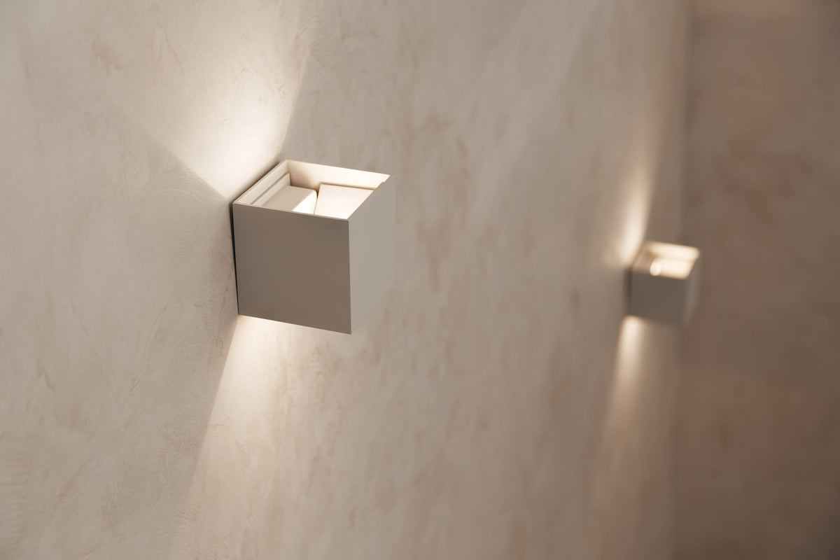 Pair of brushed brass wall sconces flanking a bathroom mirror above a vanity