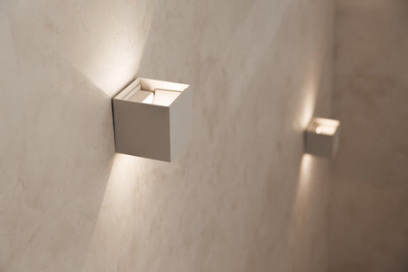 Pair of brushed brass wall sconces flanking a bathroom mirror above a vanity