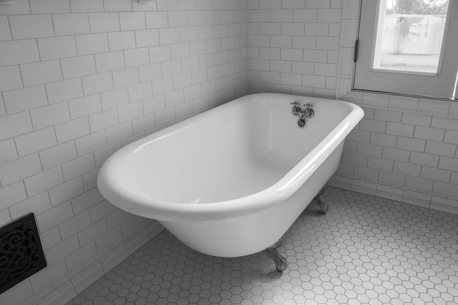 White cast iron clawfoot bathtub in a bright renovated bathroom