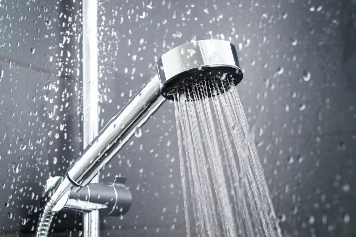 Water falling from a shower behind glass