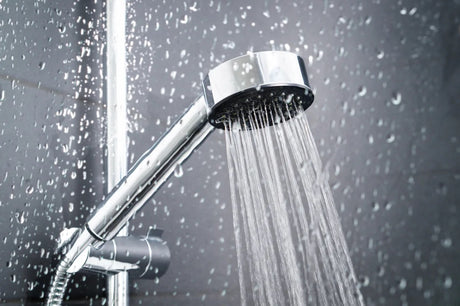 Water falling from a shower behind glass