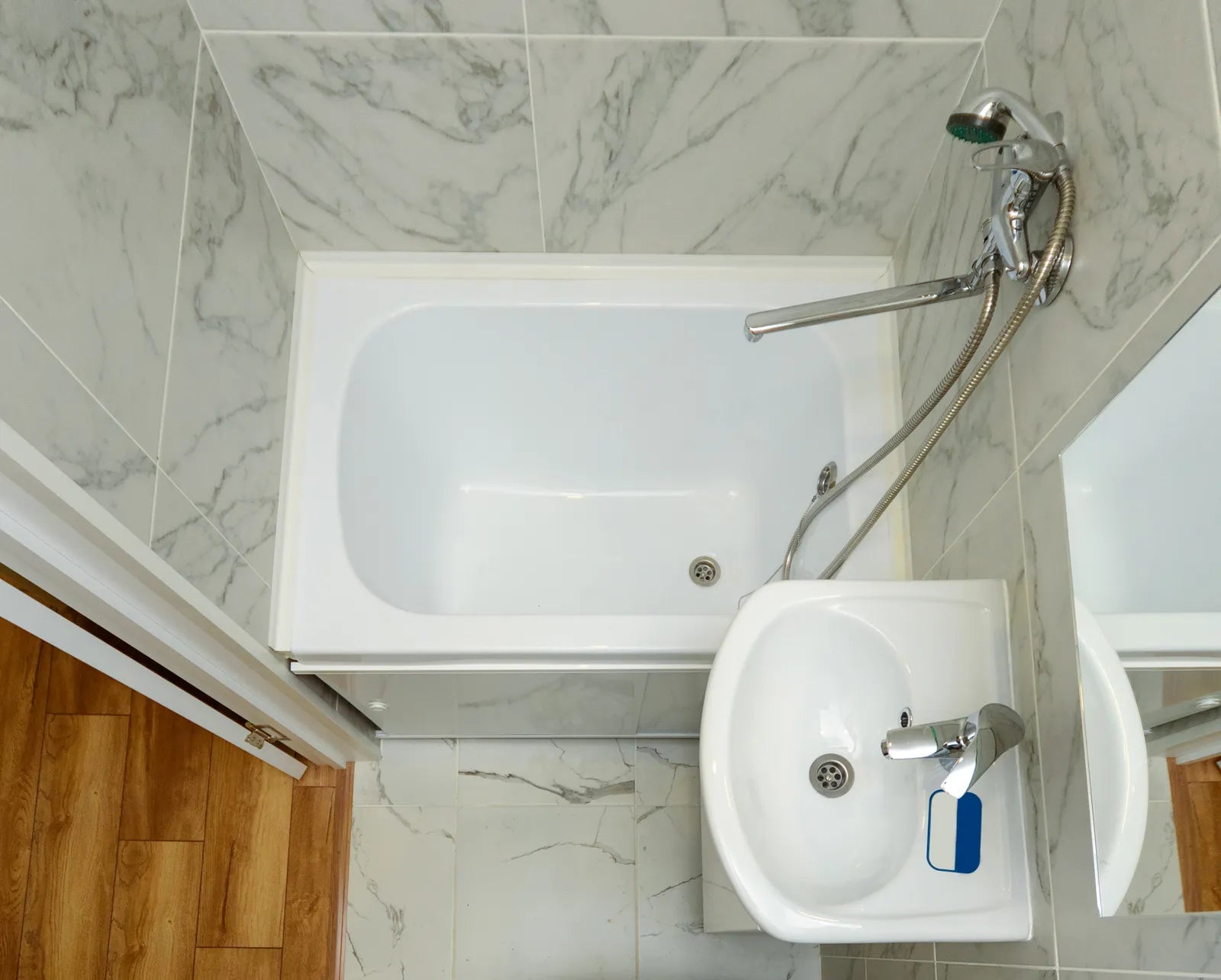 Compact deep soaking bathtub in a small bathroom alcove