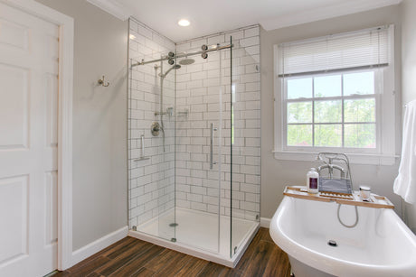 Curbless walk-in shower with a large-format tile floor sloping gently toward a linear drain along the back wall