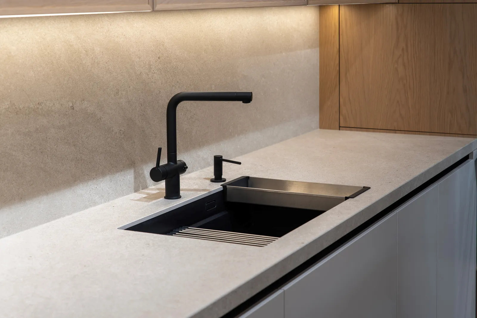 Close-up of a matte black kitchen faucet with water droplets on its finish