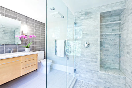 Frameless walk-in shower with thick tempered glass panels in a modern bathroom