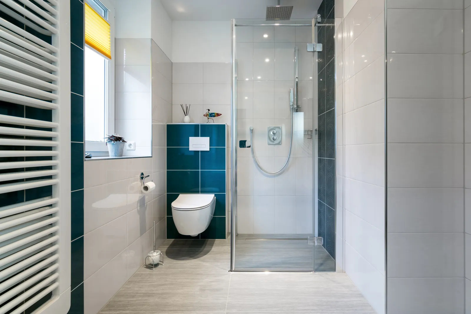 Modern walk-in shower with a low-profile shower base, tiled walls and frameless glass door