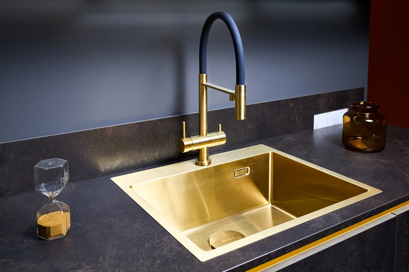 Close-up of a polished solid brass luxury kitchen faucet mounted on a marble countertop