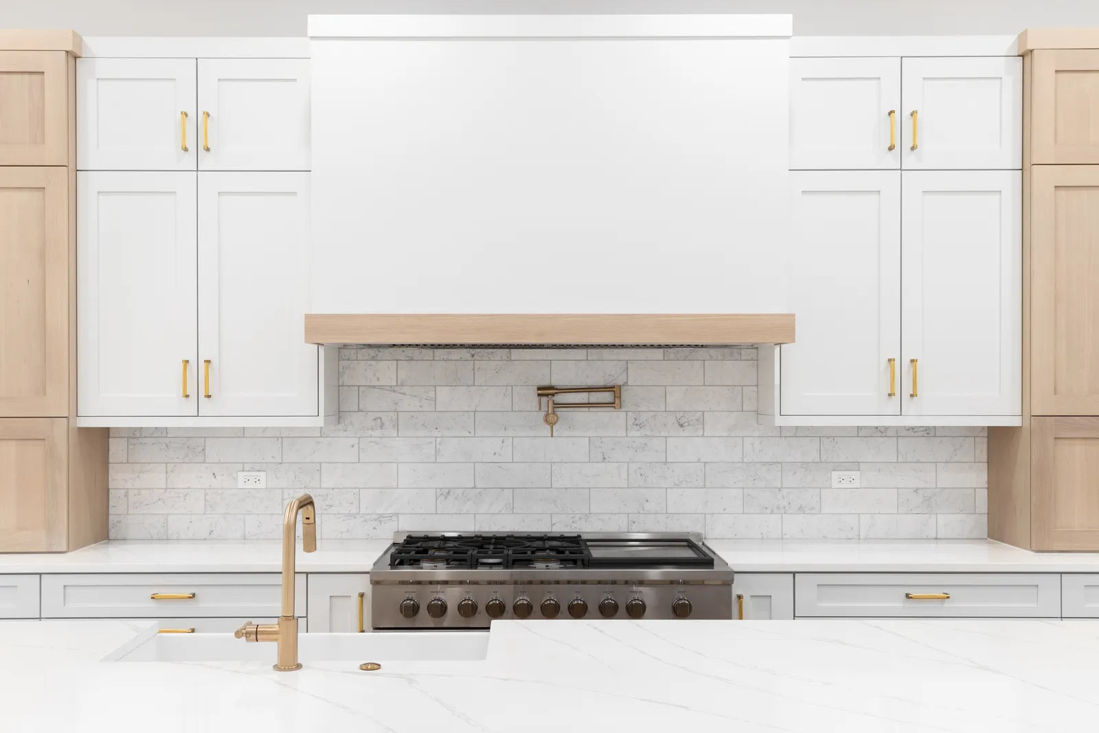 Wall-mounted pot filler faucet extended over a large pot on a gas range