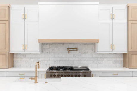 Wall-mounted pot filler faucet extended over a large pot on a gas range