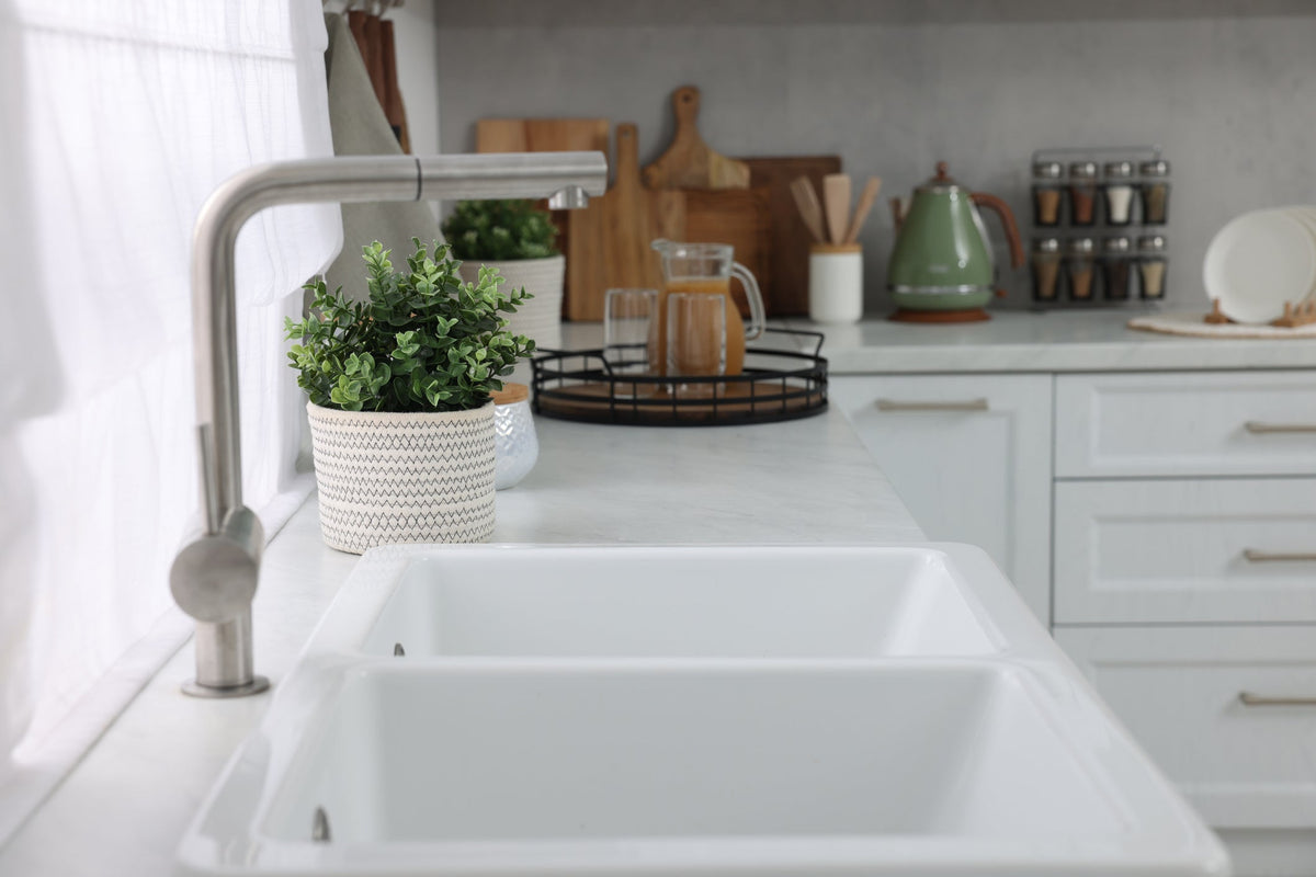 Large single-bowl workstation kitchen sink with sliding cutting board and drying rack in a modern Canadian kitchen