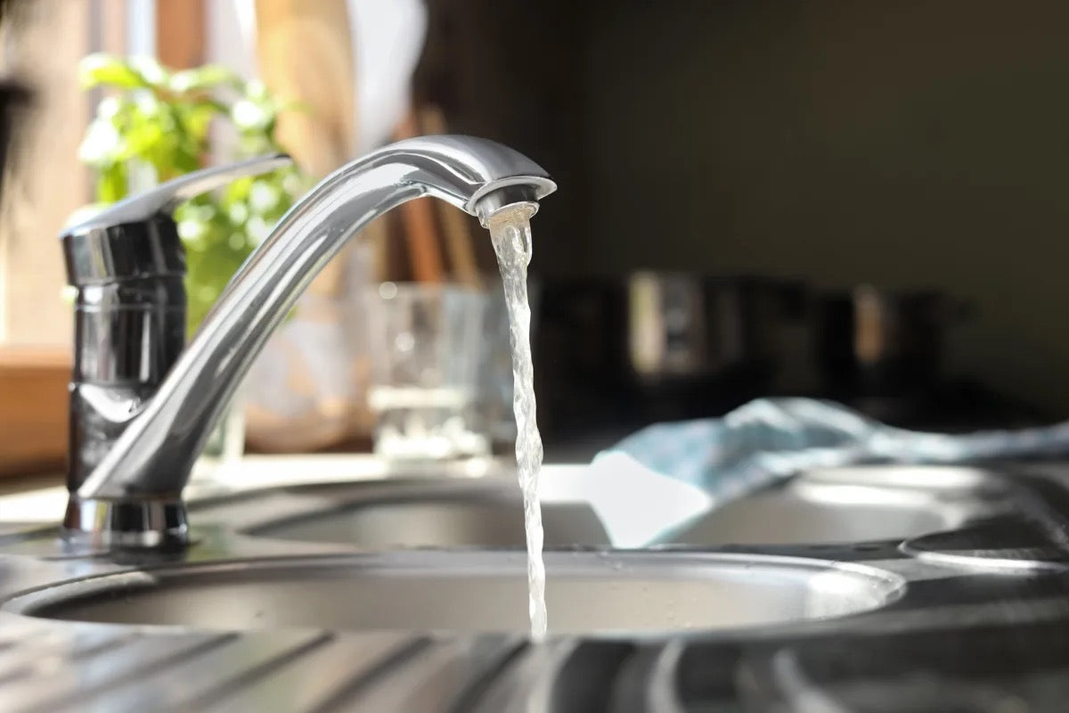 Water running from a tap into a kitchen sink