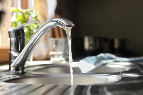 Water running from a tap into a kitchen sink