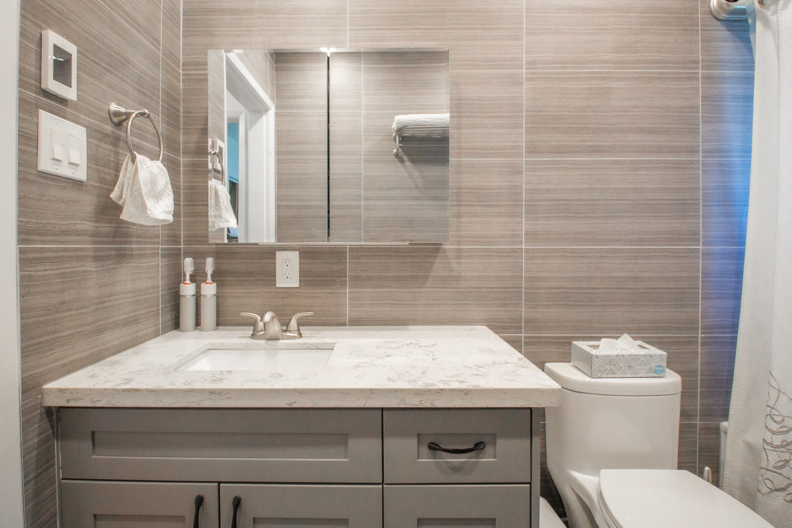 Mirrored medicine cabinet mounted above a modern bathroom vanity with soft integrated lighting