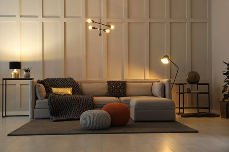Sculptural ceramic table lamp casting a warm glow on a wood console in a styled living room