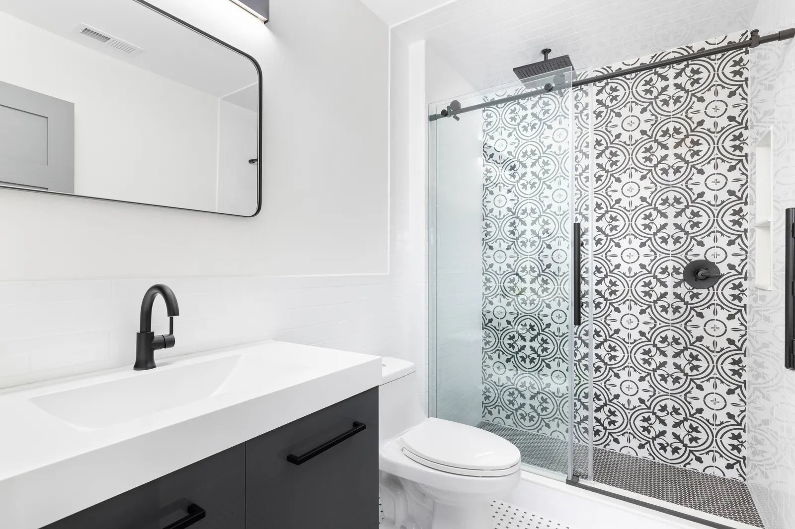 Modern bathroom with a sliding glass shower door over a tub-shower alcove
