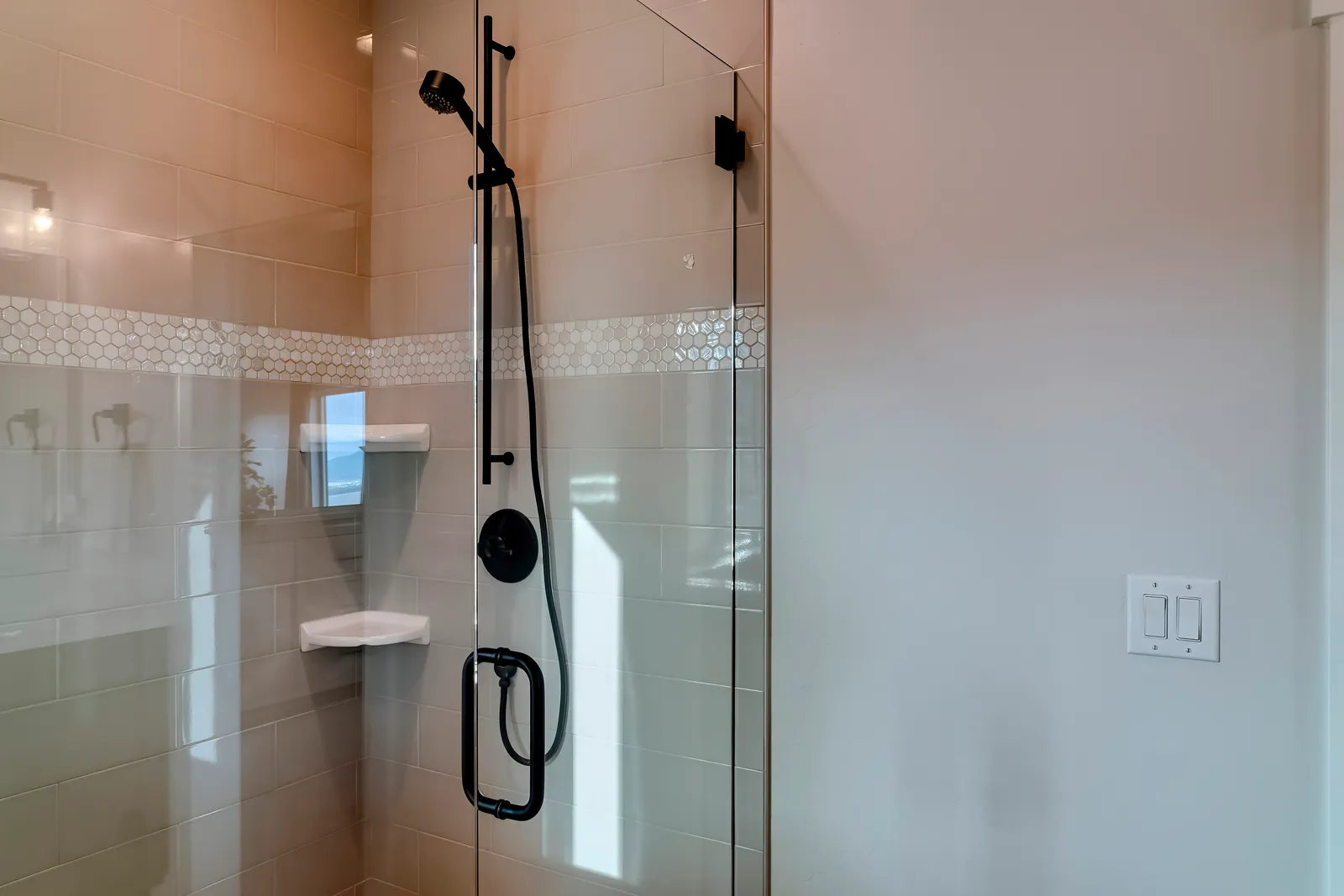 Modern bathroom with a frameless glass shower enclosure beside a semi-frameless style door with slim metal framing