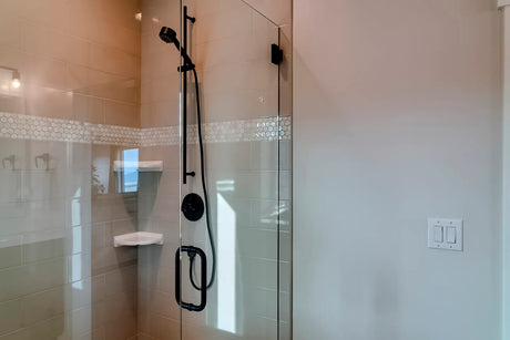 Modern bathroom with a frameless glass shower enclosure beside a semi-frameless style door with slim metal framing
