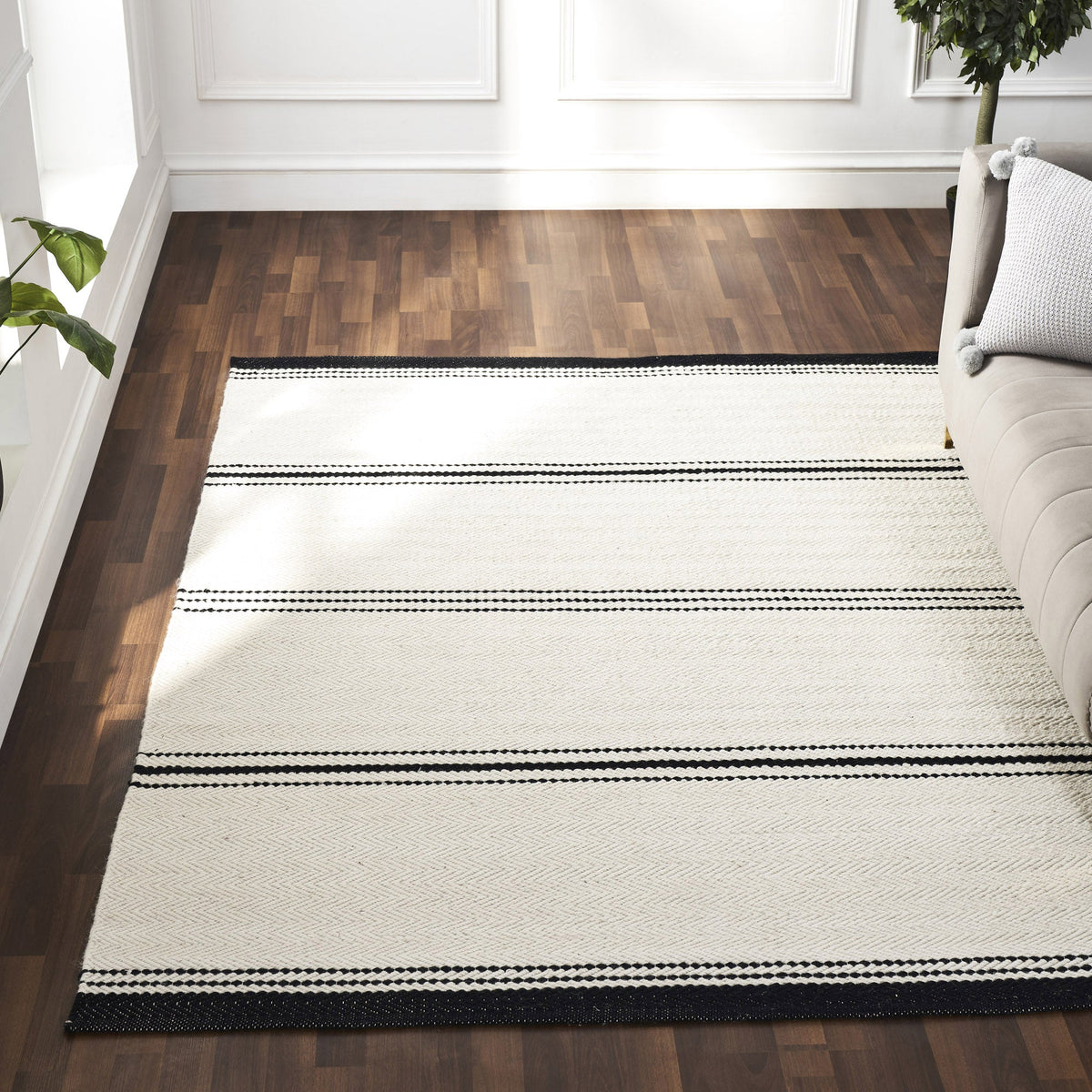 Modern neutral area rug anchoring a contemporary Canadian living room with sofa and floor lamp