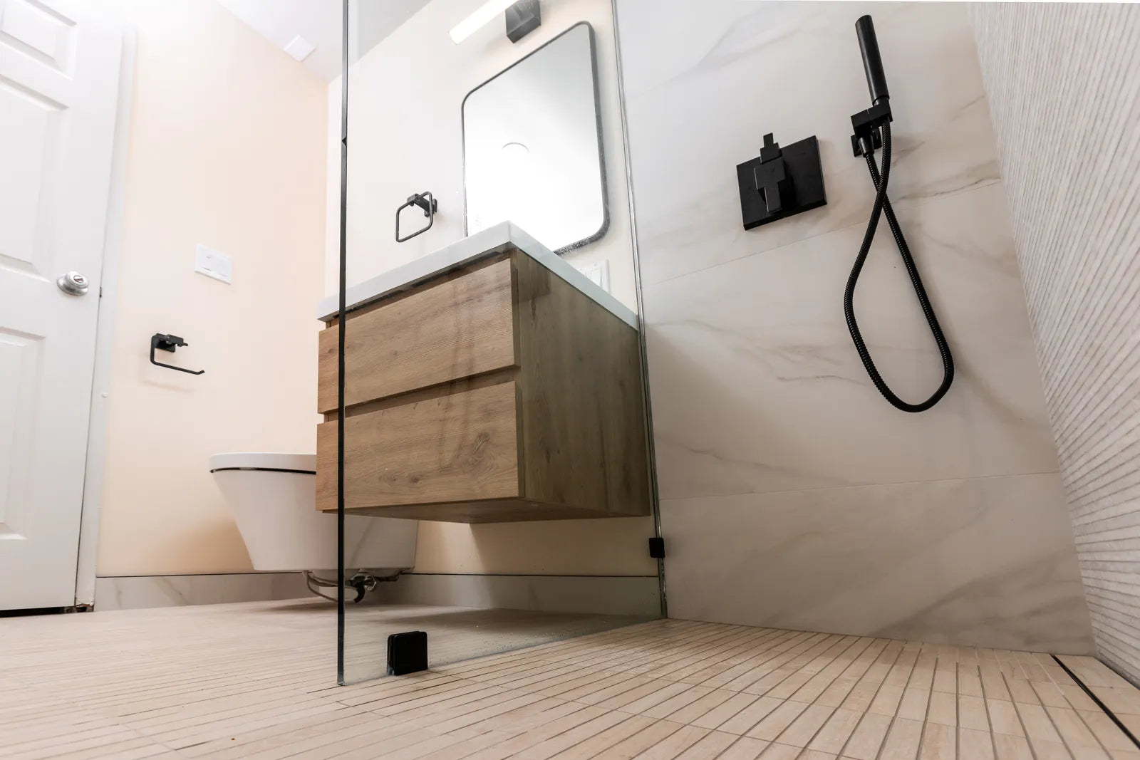 Modern curbless walk-in shower with linear drain and fixed glass panel