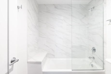 Bright bathroom with a white alcove bathtub, tiled surround and a glass shower door
