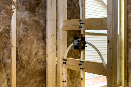 Rough-in shower valve body installed between wall studs before drywall goes up