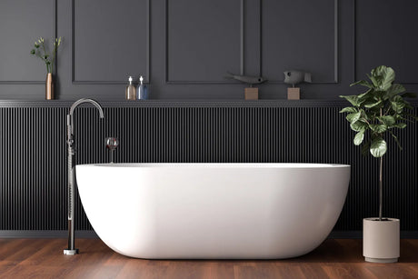 White freestanding soaker bathtub in a bright modern bathroom with a floor-mounted tub filler