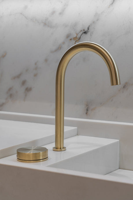 Brushed and polished faucet finishes displayed side by side in a bathroom fixture showroom