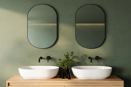 Modern double vanity with two sinks, twin mirrors and wall sconces in a bright bathroom