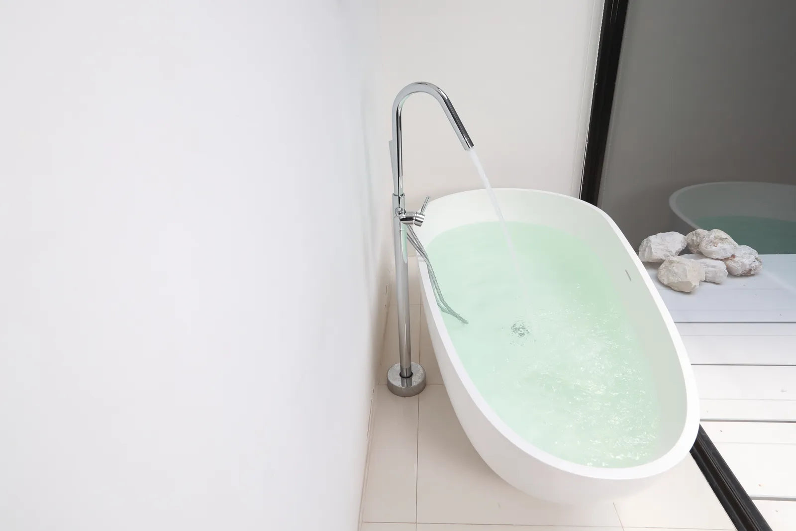 Freestanding bathtub with a floor-mounted tub filler in a modern bathroom