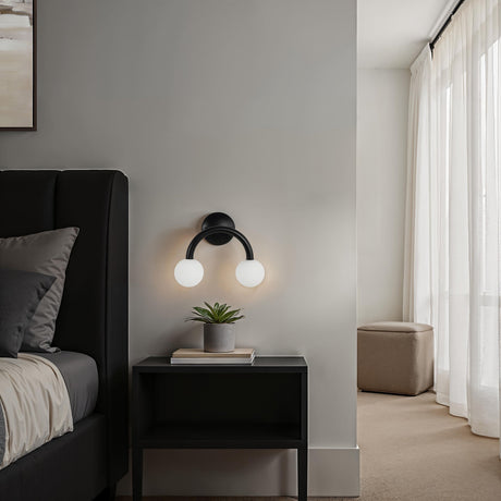Renwil Santo double-light wall sconce installed above a nightstand in a modern bedroom
