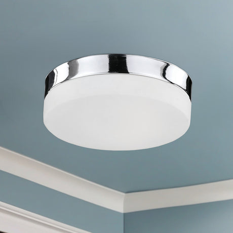 Kuzco Lomita 11-inch LED flush mount in Chrome installed on a ceiling with crown moulding