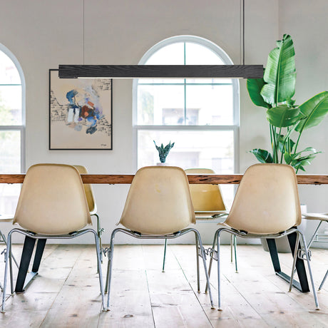 Beige chairs around a wooden dining table with a plant and artwork in the background.